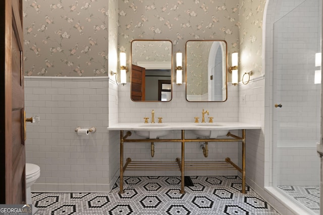 bathroom featuring tile patterned floors, sink, tile walls, and toilet