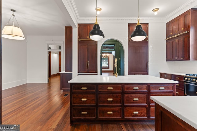 kitchen with pendant lighting, crown molding, sink, high end stainless steel range oven, and dark hardwood / wood-style floors