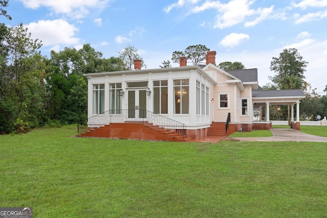 back of house with a lawn and a sunroom