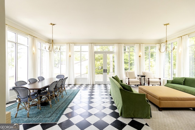 sunroom / solarium with a chandelier, a healthy amount of sunlight, and french doors