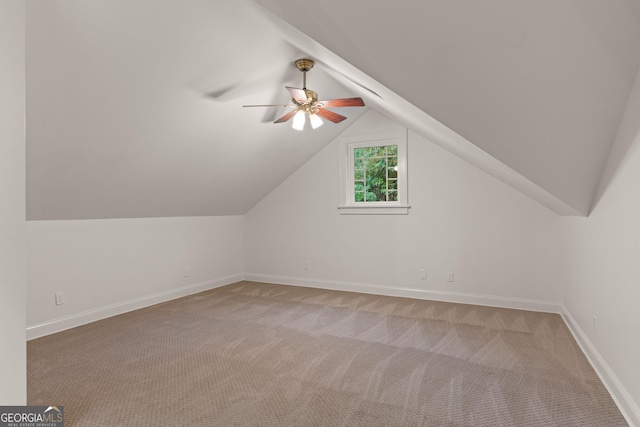 additional living space with light colored carpet, vaulted ceiling, and ceiling fan