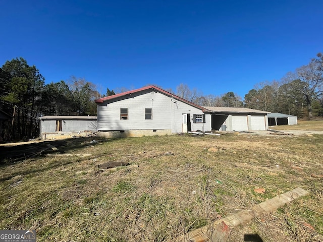 back of house featuring a yard and a garage