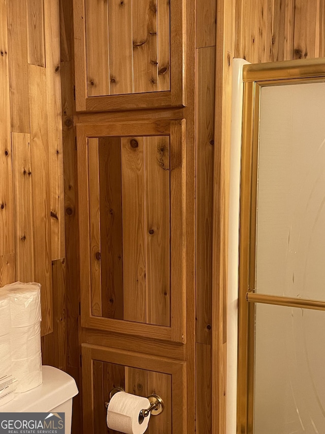 room details featuring wooden walls and toilet