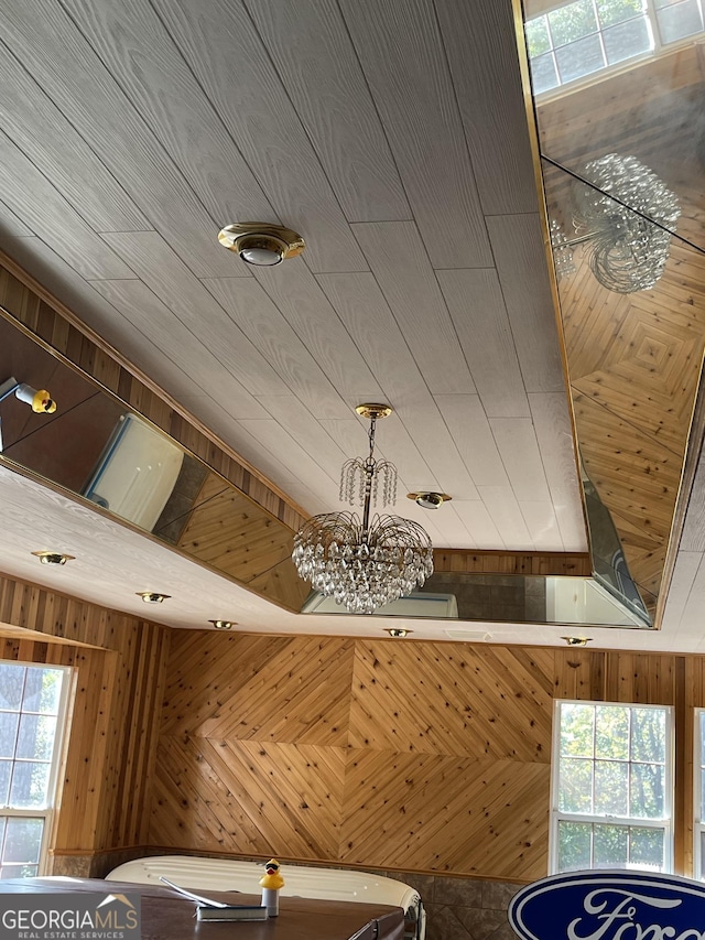 details featuring an inviting chandelier and wood walls