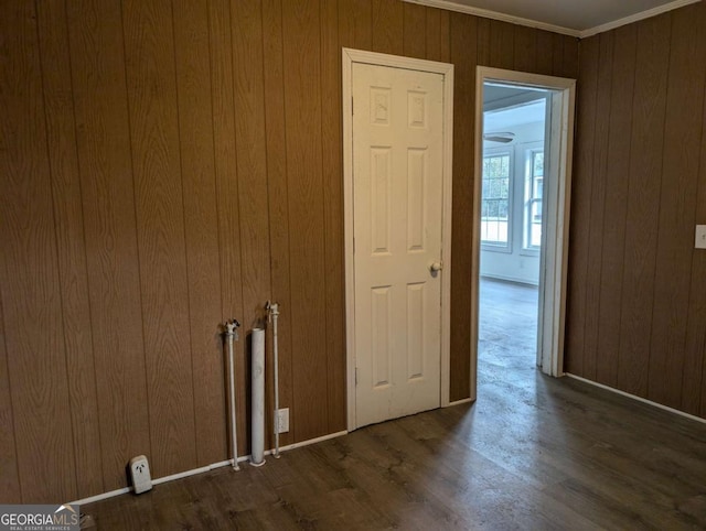 interior space with ornamental molding, dark hardwood / wood-style flooring, and wooden walls