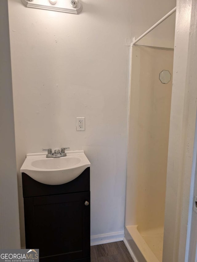 bathroom featuring vanity, hardwood / wood-style flooring, and walk in shower