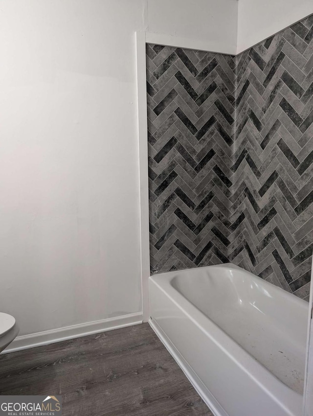 bathroom with a bath and wood-type flooring