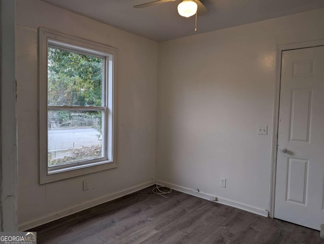 empty room with ceiling fan and dark wood-type flooring