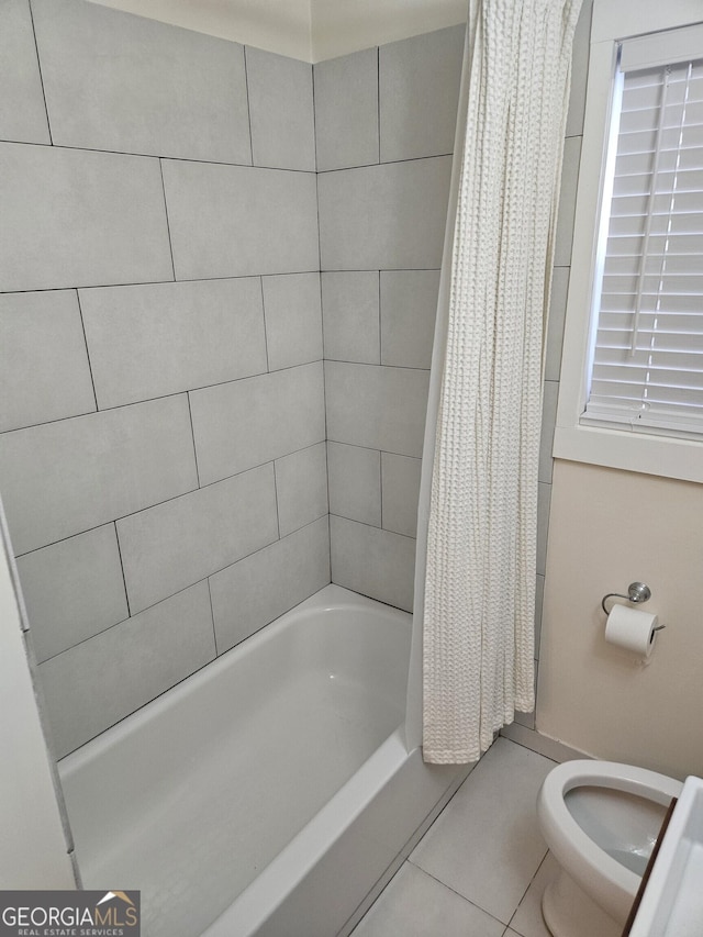 bathroom featuring tile patterned flooring, shower / tub combo, and toilet