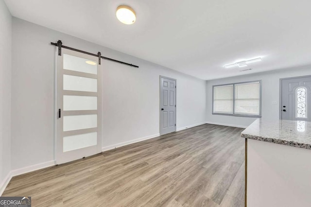 interior space featuring a barn door and light hardwood / wood-style floors