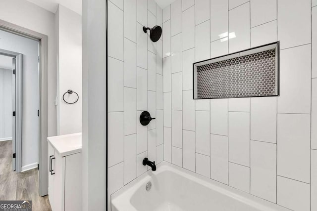 bathroom featuring vanity, tiled shower / bath combo, and hardwood / wood-style flooring