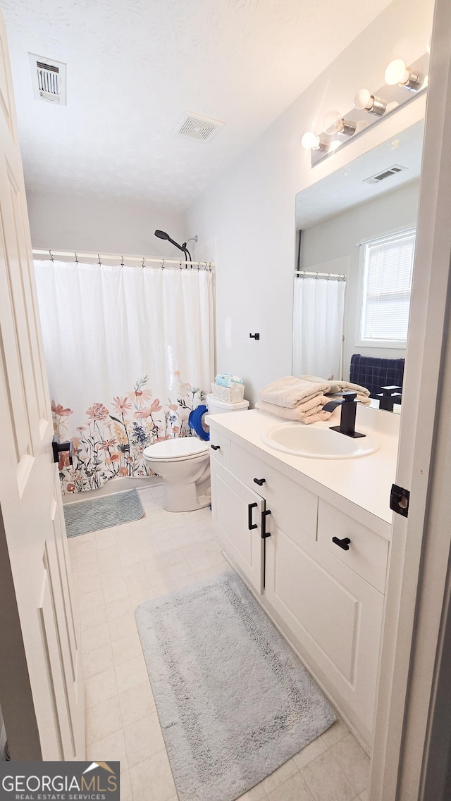 bathroom with a shower with curtain, tile patterned flooring, vanity, and toilet