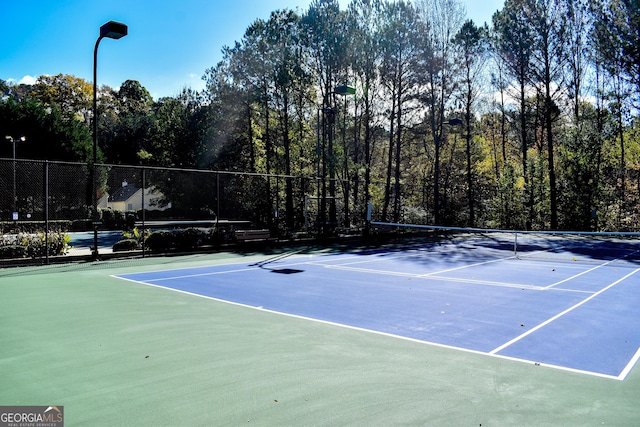 view of tennis court featuring basketball hoop