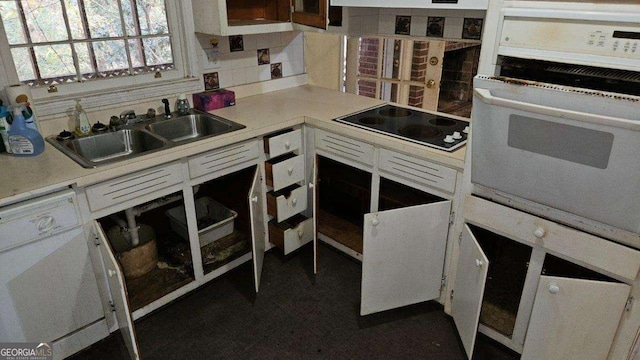 kitchen featuring white appliances, tasteful backsplash, white cabinetry, and sink