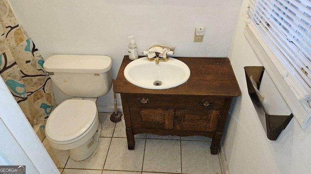 bathroom featuring tile patterned floors, a wealth of natural light, vanity, and toilet