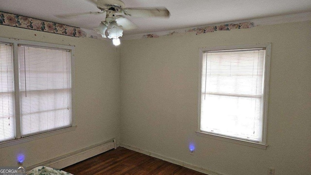 empty room featuring baseboard heating, ceiling fan, and dark wood-type flooring