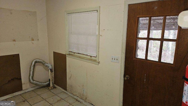 entryway with a wealth of natural light and light tile patterned flooring