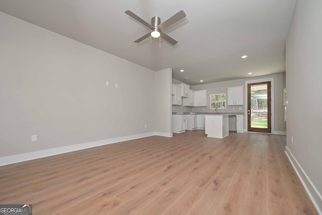 unfurnished living room featuring sink, light hardwood / wood-style flooring, and ceiling fan