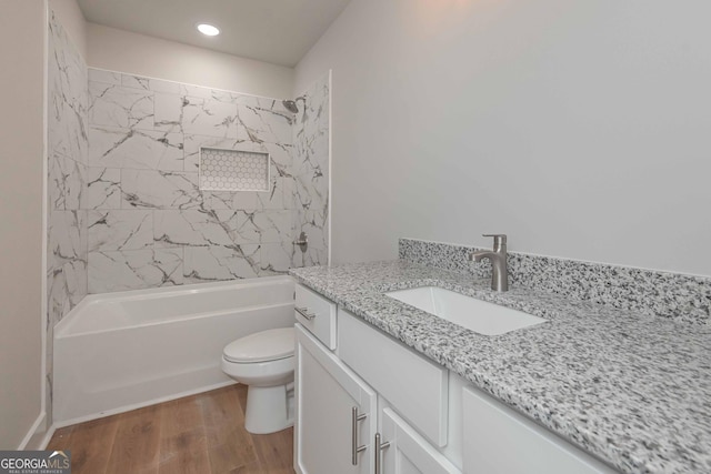 full bathroom featuring vanity, hardwood / wood-style floors, toilet, and tiled shower / bath