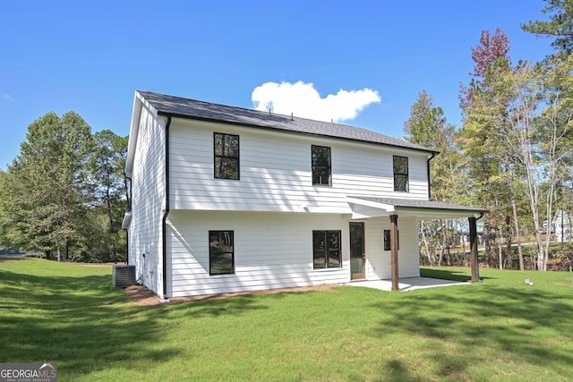 rear view of house featuring central AC unit, a yard, and a patio area