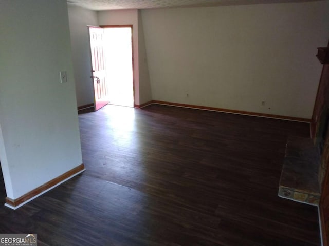 spare room with dark hardwood / wood-style flooring and a textured ceiling