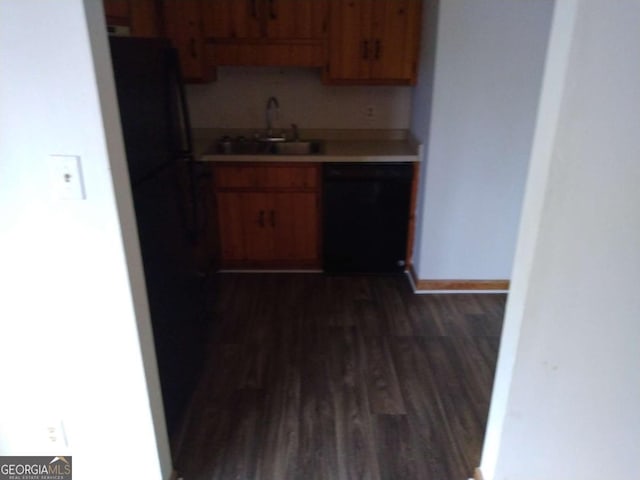 kitchen with dark wood-type flooring, black appliances, and sink