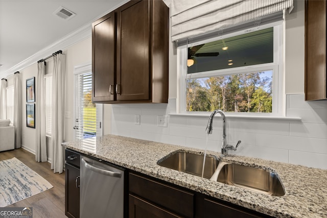 kitchen featuring backsplash, light stone counters, sink, dishwasher, and dark hardwood / wood-style floors