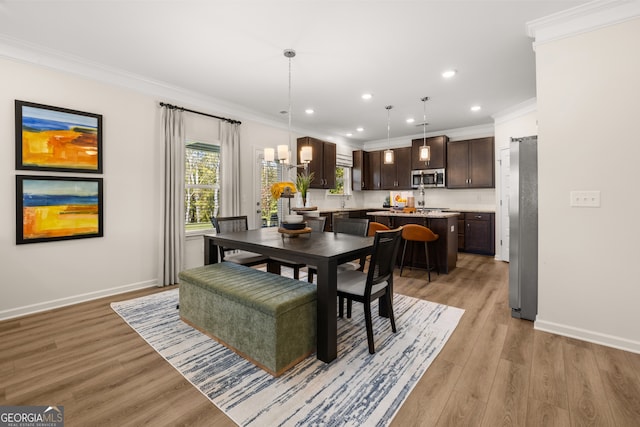 dining space featuring light wood-type flooring and crown molding