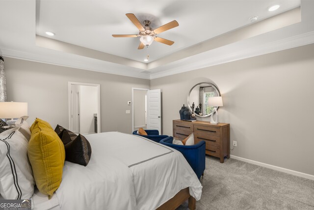 bedroom featuring ceiling fan, a raised ceiling, light carpet, and crown molding