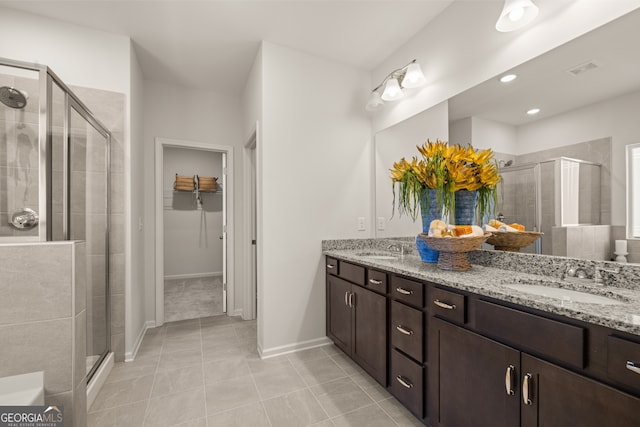 bathroom featuring tile patterned flooring, vanity, and a shower with door