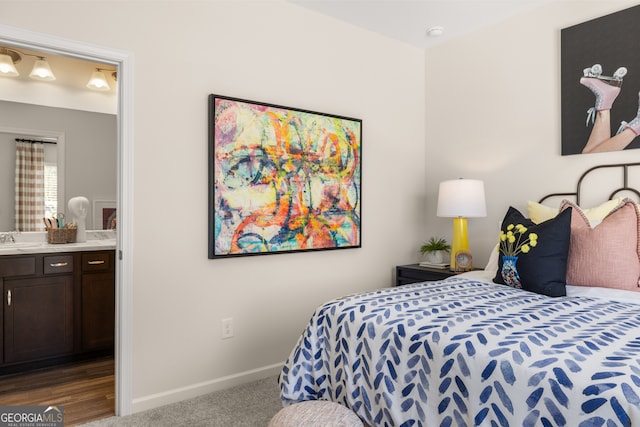 carpeted bedroom featuring ensuite bathroom and sink