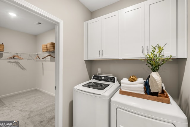 laundry area featuring light carpet, cabinets, and washer and dryer