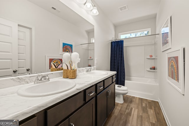 full bathroom featuring hardwood / wood-style floors, vanity, shower / bath combination with curtain, and toilet