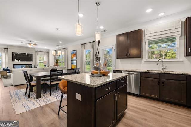 kitchen featuring ceiling fan, a center island, sink, light hardwood / wood-style flooring, and stainless steel dishwasher