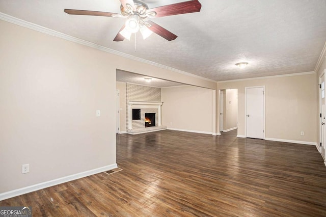 unfurnished living room featuring ceiling fan, ornamental molding, a textured ceiling, a fireplace, and dark hardwood / wood-style flooring