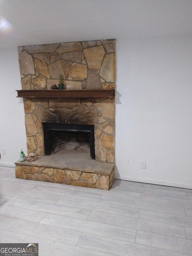 room details with a stone fireplace and hardwood / wood-style flooring