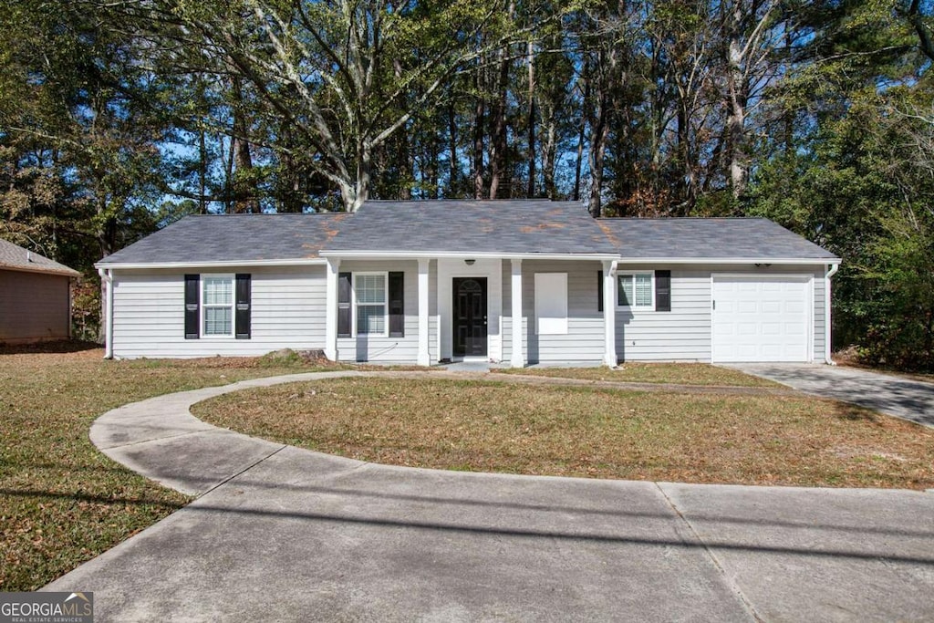 ranch-style home featuring a garage and a front yard