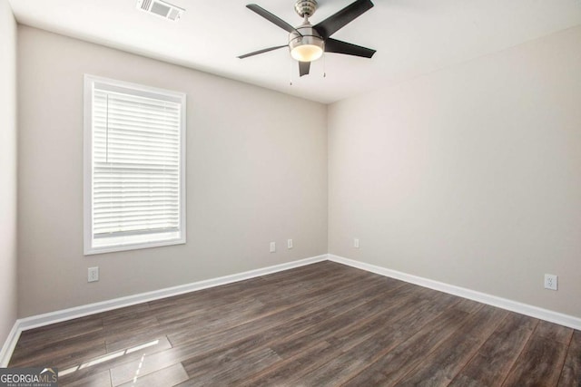 empty room featuring ceiling fan, dark hardwood / wood-style flooring, and a healthy amount of sunlight