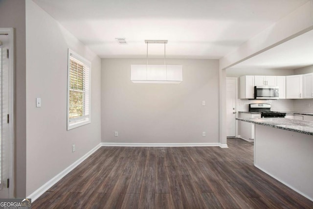 kitchen featuring white cabinetry, dark hardwood / wood-style flooring, decorative light fixtures, and appliances with stainless steel finishes