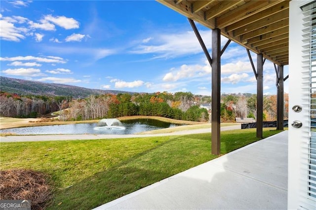 view of community featuring a lawn and a water view