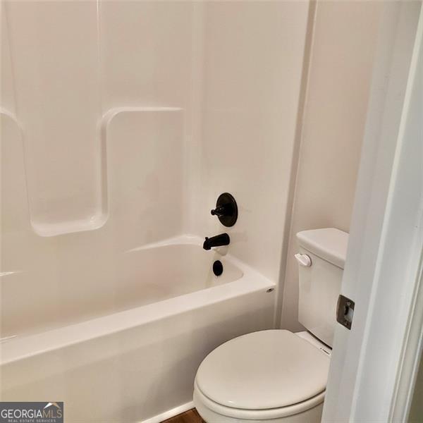 bathroom with tub / shower combination and toilet