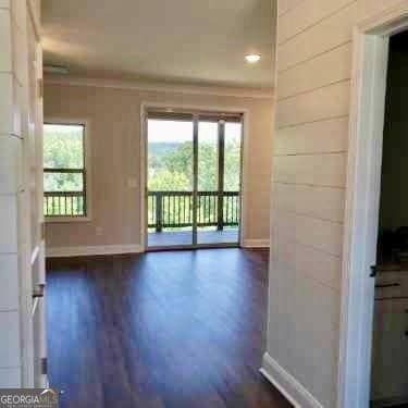 spare room with crown molding and dark hardwood / wood-style flooring