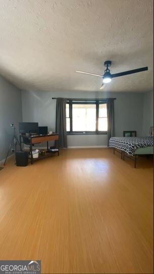 interior space with hardwood / wood-style floors, a textured ceiling, and ceiling fan