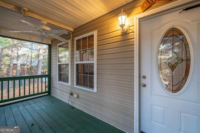 view of exterior entry featuring a porch and ceiling fan