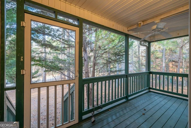 unfurnished sunroom with wood ceiling, plenty of natural light, and ceiling fan