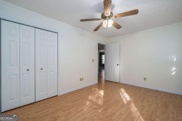 unfurnished bedroom featuring a closet, ceiling fan, light hardwood / wood-style flooring, and a textured ceiling