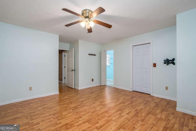 unfurnished room with a textured ceiling, light hardwood / wood-style floors, and ceiling fan