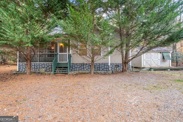 view of property hidden behind natural elements with a storage unit