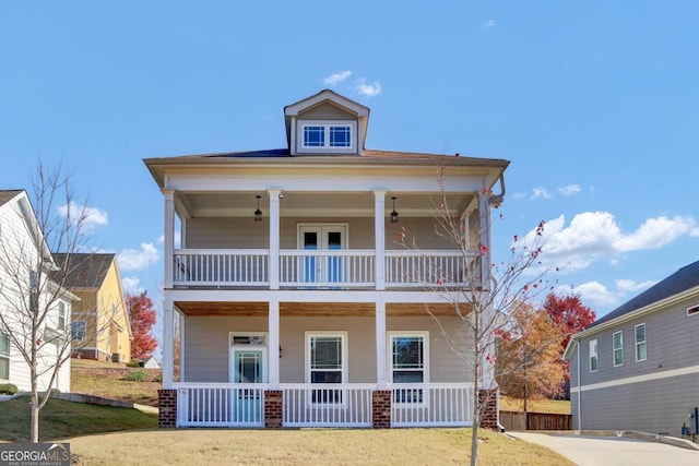 view of front of property featuring a balcony and a front yard