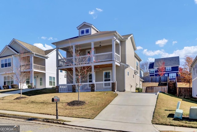 view of front of property with covered porch, a balcony, and a front lawn